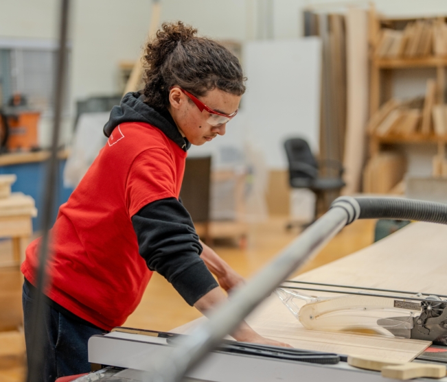 Cabinetmaking student cuts wood