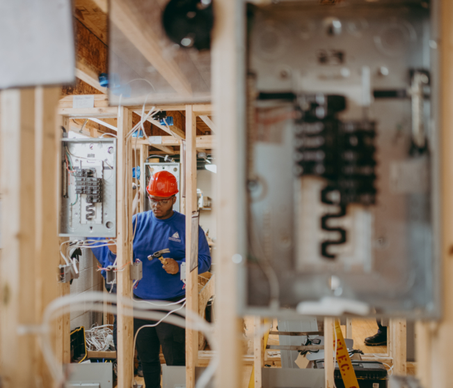 Electrical Construction student wiring between wall panels