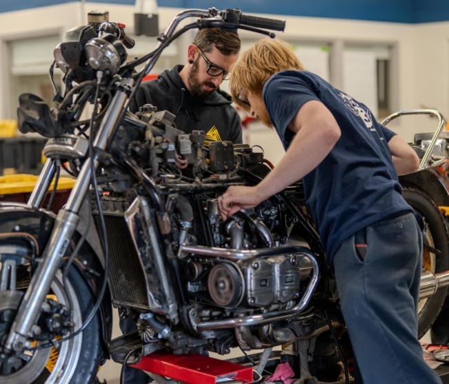 Student works with instructor on motorcycle