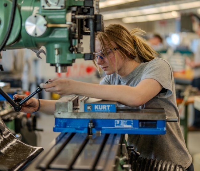 Student operates precision machinery