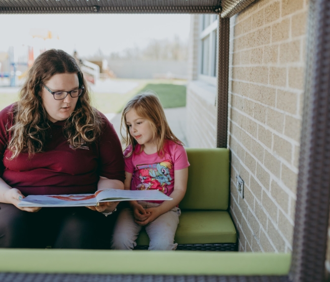 student reads book to child