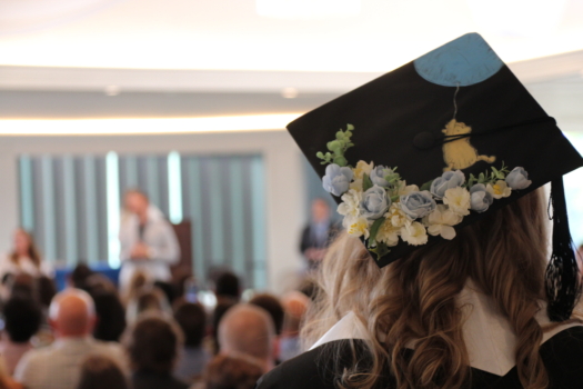 Student wearing Winnie the Pooh grad cap looks on