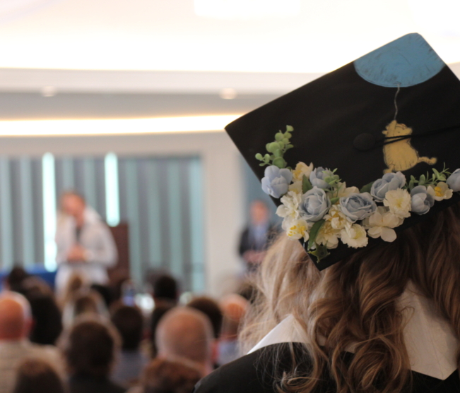 Student wearing Winnie the Pooh grad cap looks on
